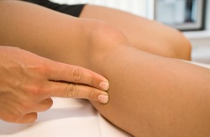 Physiotherapeutin untersucht ein Bein