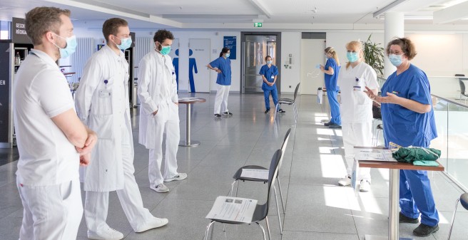 Sonja Biel während einer Hygieneschulung mit drei Ärzten, sie halten einen großen Abstand