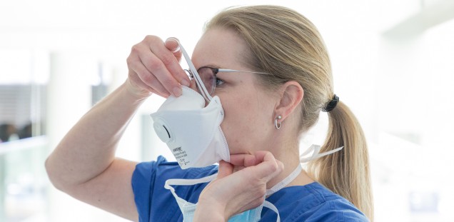 Peggy Jaehnisch zeigt während einer Hygieneschulung, wie die Atemschutzmaske richtig aufgesetzt wird, Bild 3 von 5