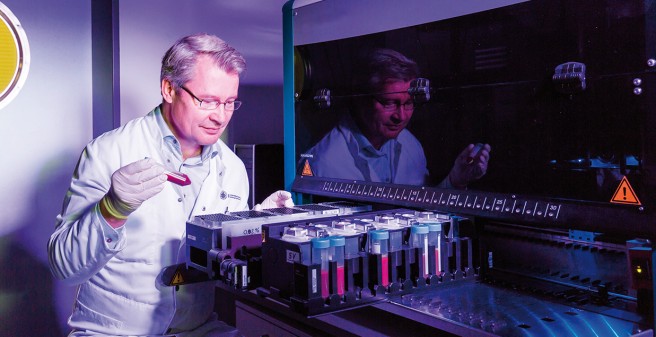 Prof. Dr. Klaus Pantel kontrolliert die Proben- beschickung an einem Gerät zur automatisierten Anreicherung von Tumorzellen aus dem Blut von Krebspatienten