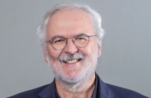 Porträtaufnahme von Prof. Dr. Burkhard Göke, er trägt ein schwarzes Hemd, dunkelblaues Jacket und das Logo des UKE am Revers