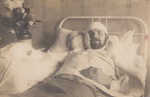 Mann mit Kopfverbind in einem Krankenbett