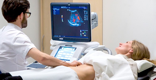 Arzt führt Ultraschall-Untersuchung der Leber bei Patientin durch